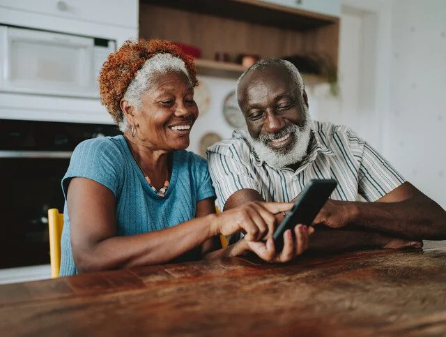 Portrait senior couple using smartphone at home