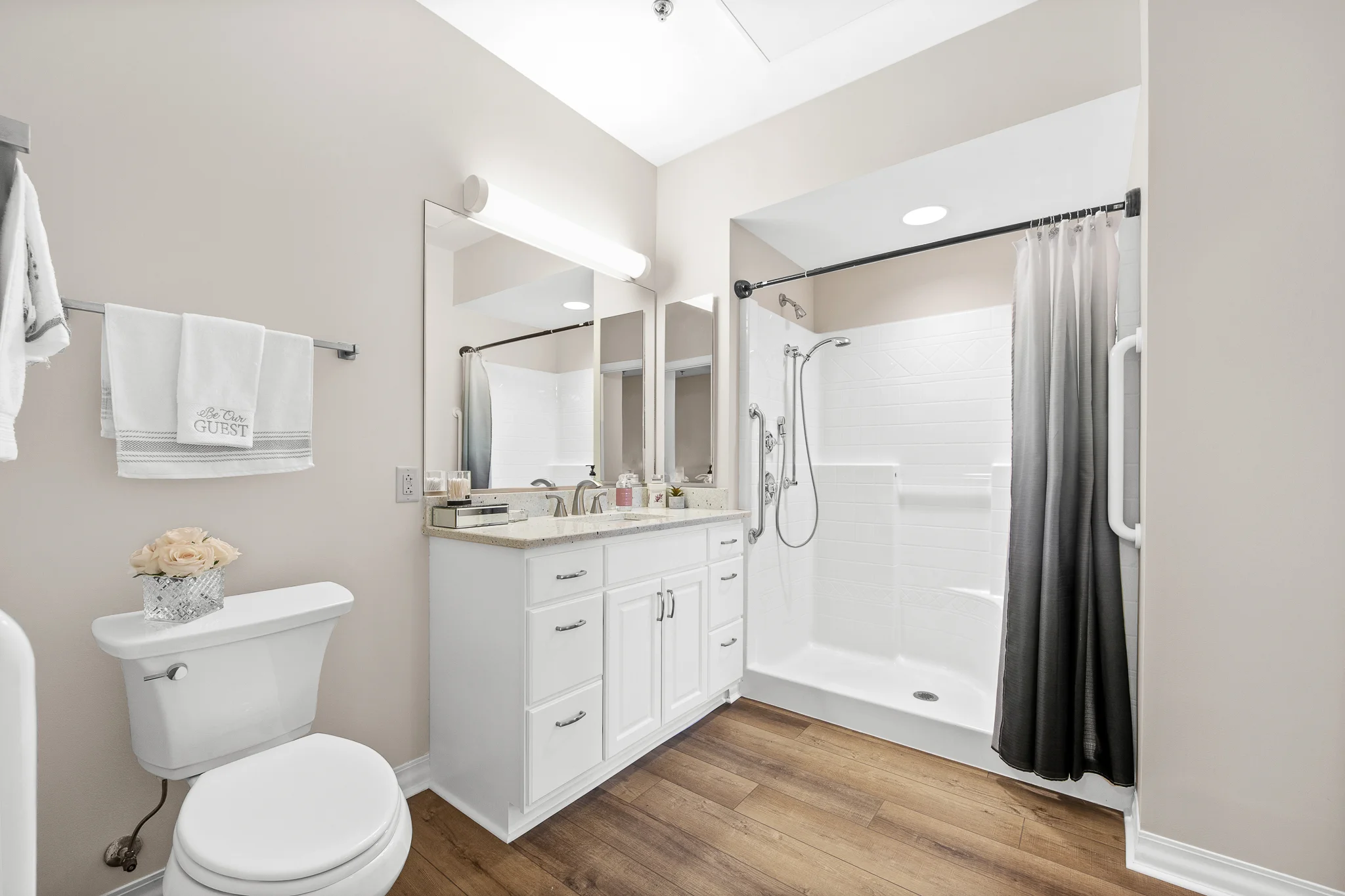 toilet and sink in a stylish bathroom with walk in shower