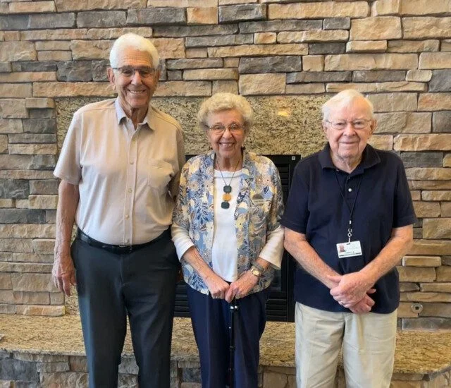three seniors standing shoulder to shoulder and posing for a photo