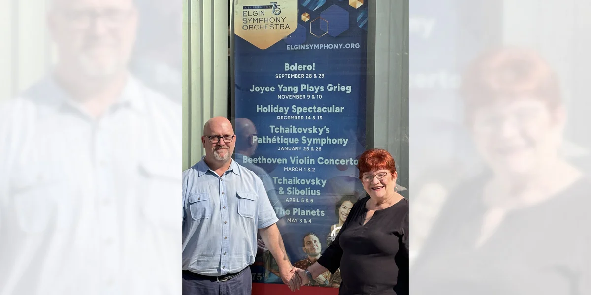 senior couple poses for a photo in front of an award