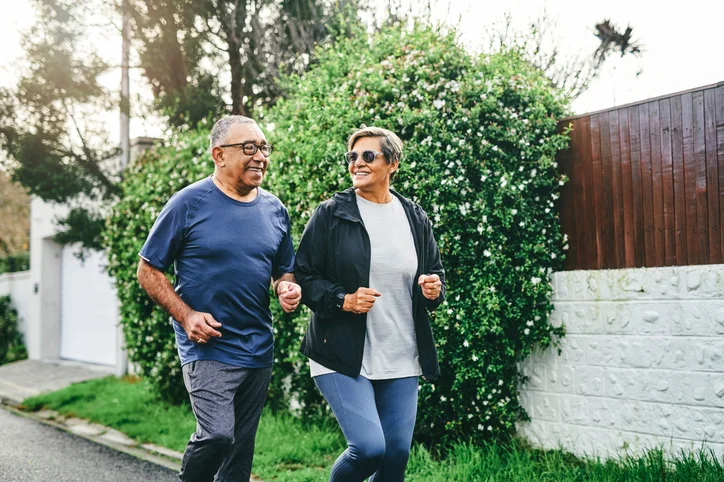 Shot of a senior couple bonding together while running outdoors