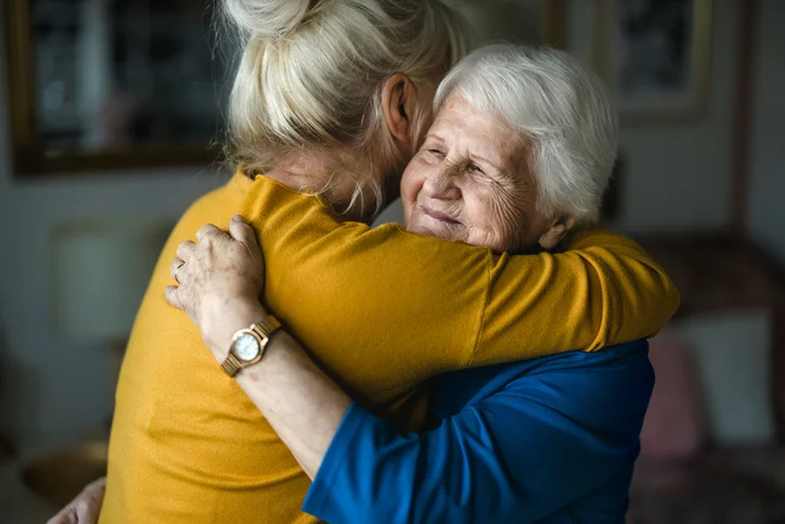 Woman hugging her elderly mother