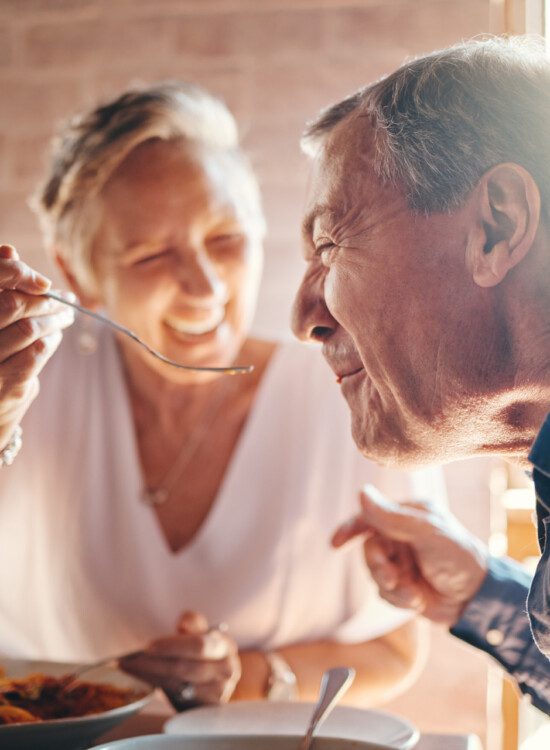 Couple, love and food with a senior man and woman on a date in a restaurant while eating on holiday. Travel, romance and dating with an elderly male and female pensioner enjoying a meal together