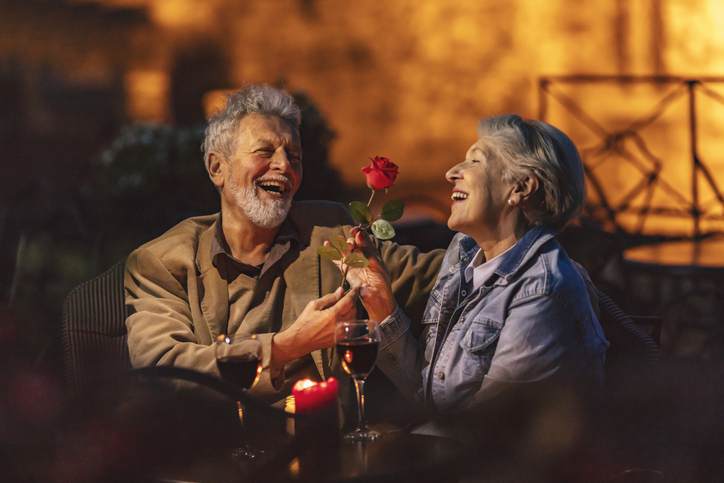 A senior man giving a senior woman a rose on a date