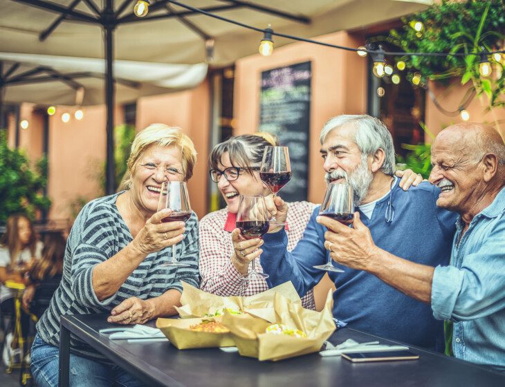 seniors enjoying a glass of wine together outdoors