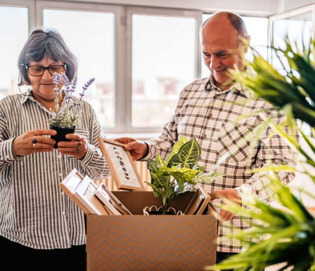 Senior couple moving items into a new living space together