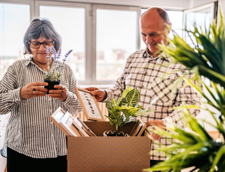 Senior couple moving items into a new living space together