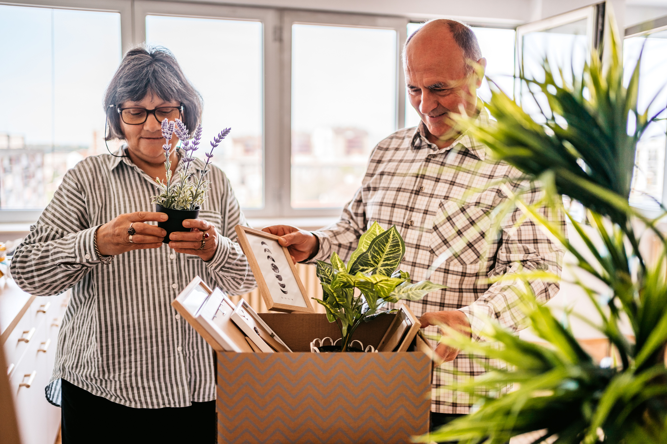 Senior couple moving items into a new living space together