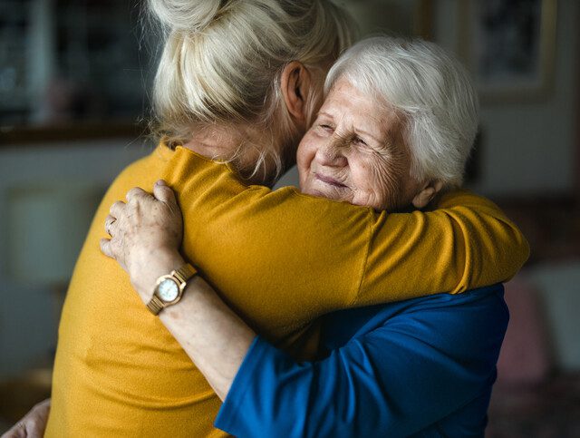 Woman hugging her elderly mother